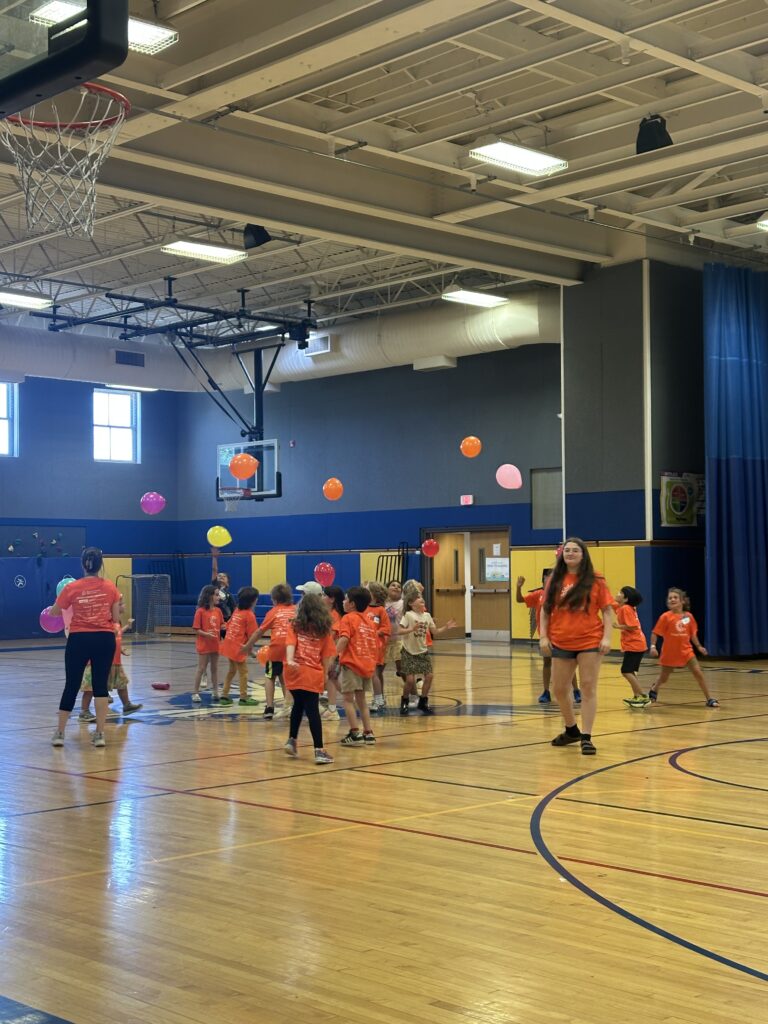Students participating in a balloon activity in the gym.