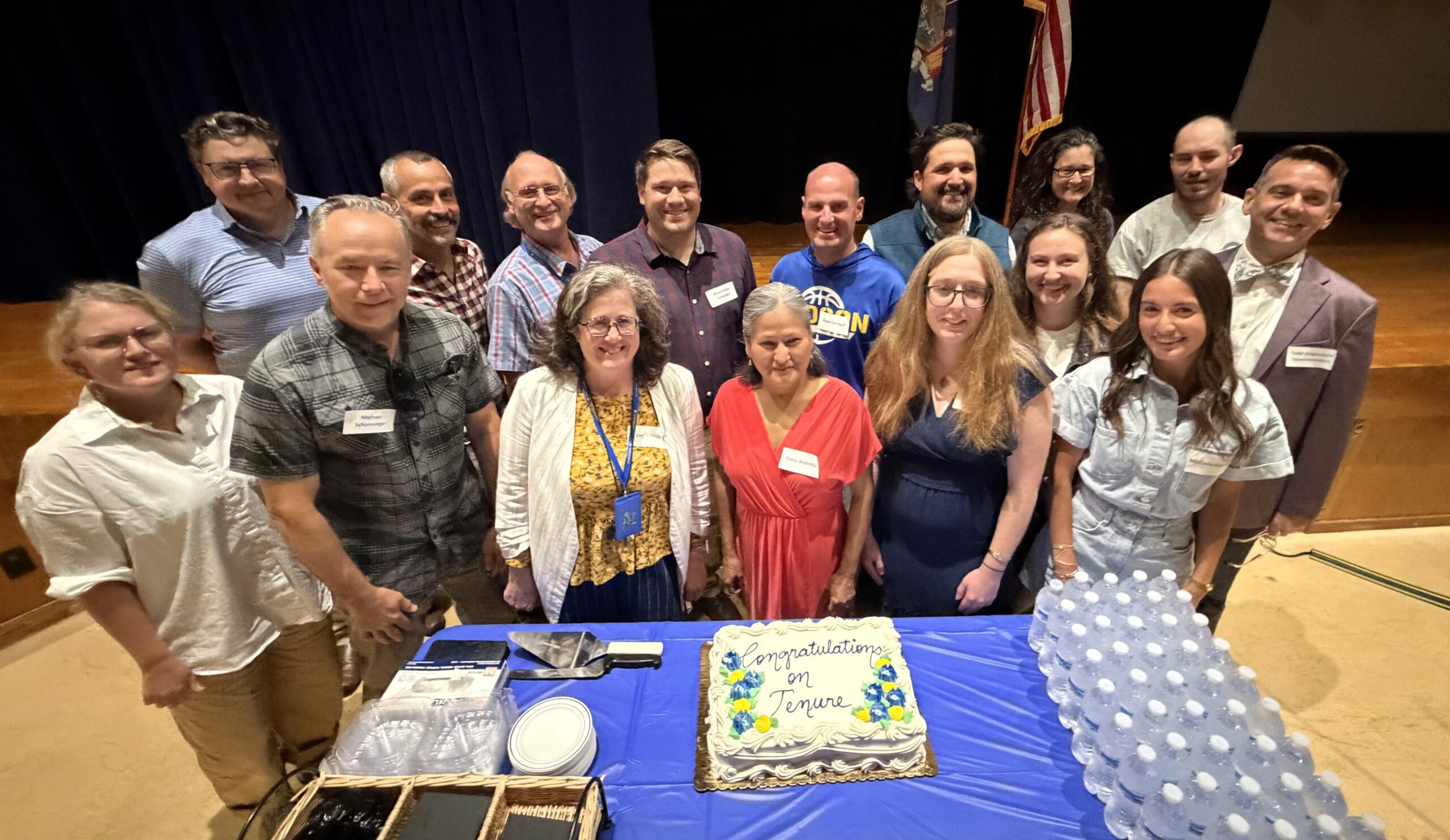 tenure faculty smile for photo with cake and BOE members